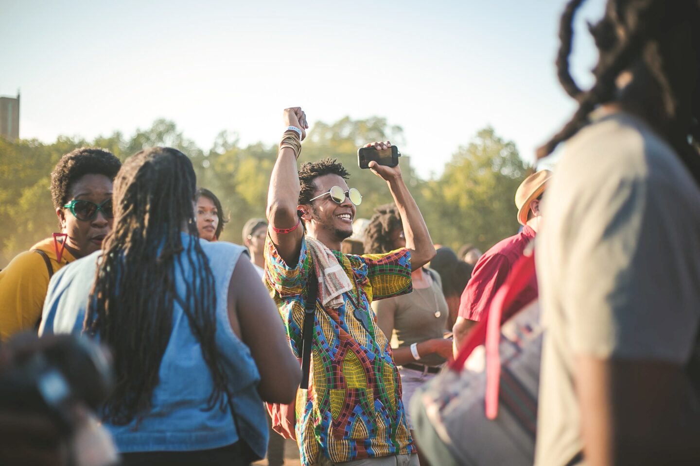 how to be more sustainable at a festival - man dancing in a colourful shirt as an outdoor festival