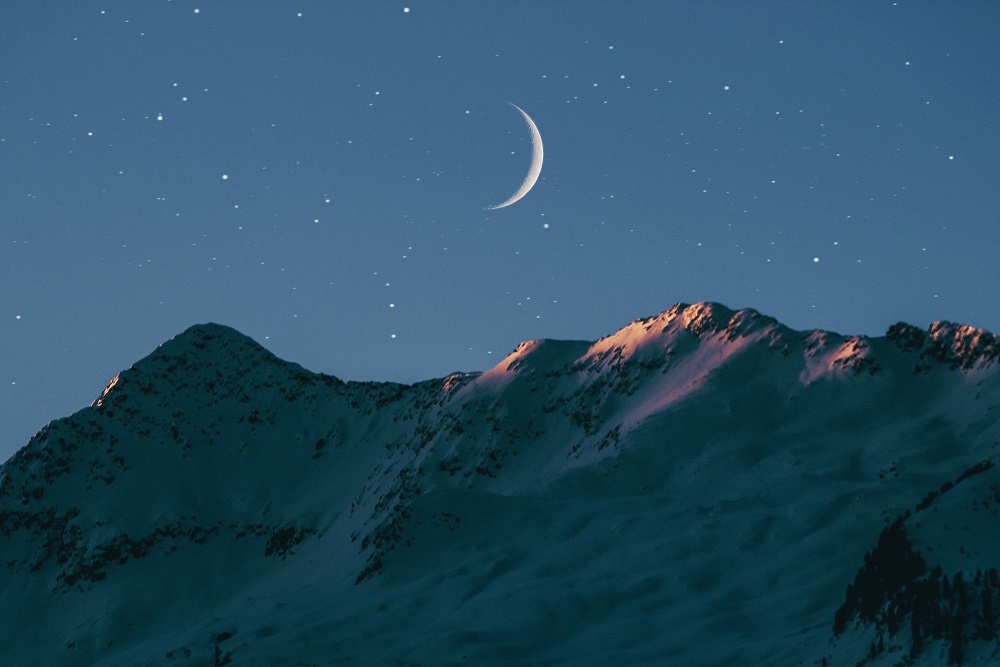 A new moon above moutains at sunrise. Looking at the effects of the new moon on your emotions 